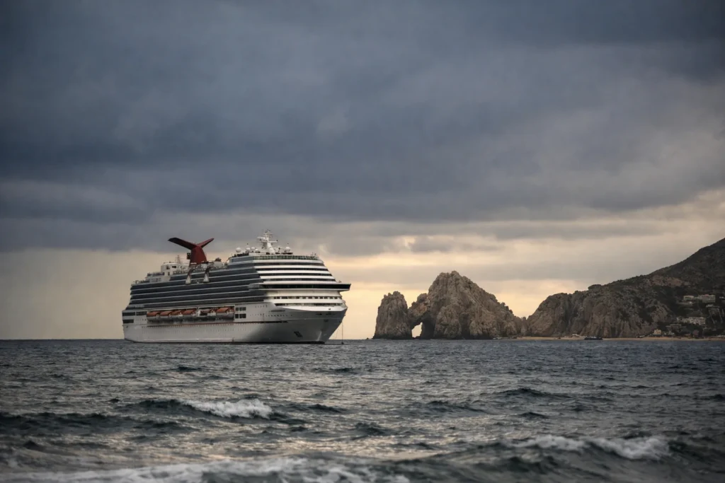 Grande navio de cruzeiro ancorado ao largo de Cabo San Lucas sob nuvens de tempestade à tarde